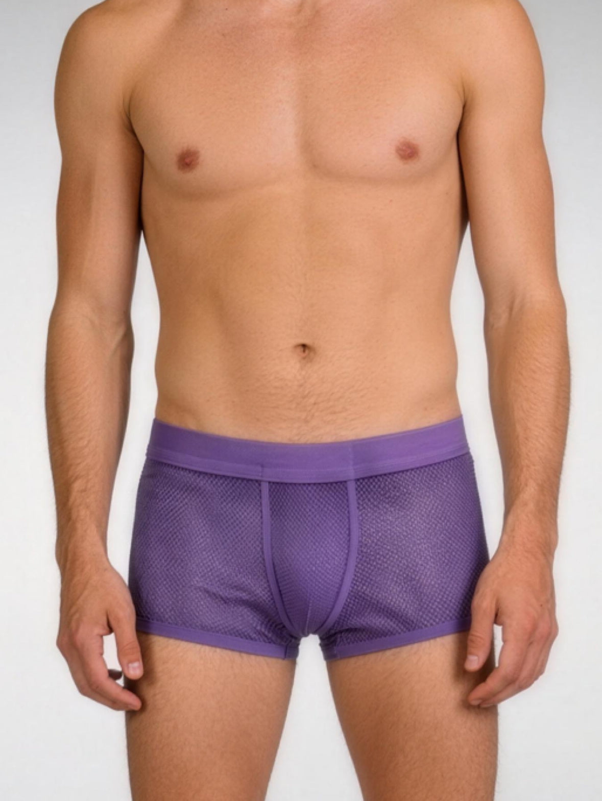Man wearing purple mesh underwear on a white background